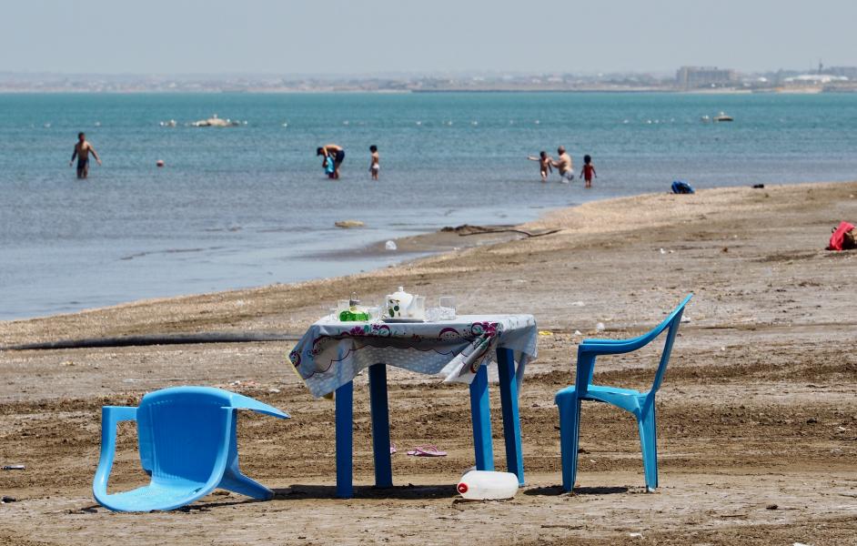 Plastiktisch und -stühle am Strand