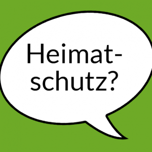Weiße Sprechblase auf grünem Grund mit der Aufschrift "Heimatschutz?"