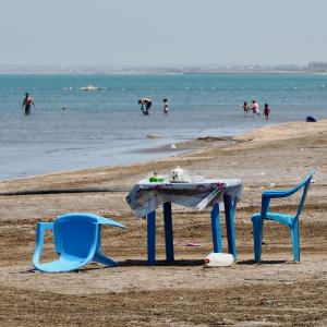 Plastiktisch und -stühle am Strand